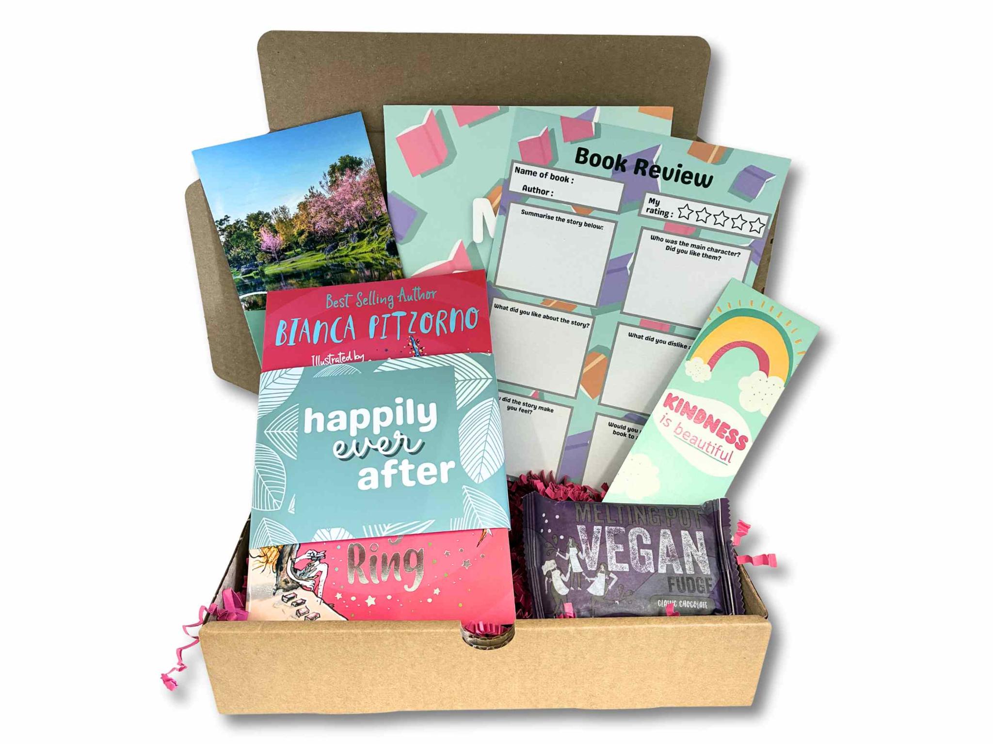 Children's Book Subscription Box open showing a surprise book, bookmark, book review sheet, and vegan treats